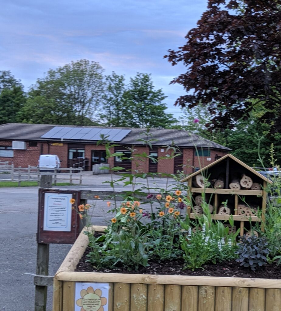 Photo Of Catterall Village Hall including plants at entrance to car park